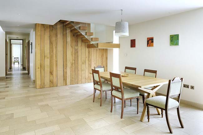 Bạn có thấy bức tường và cầu thang bằng gỗ tái chế dẫn dắt ánh nhìn của bạn một cách mãnh liệt trong thiết kế nhà ăn này không
